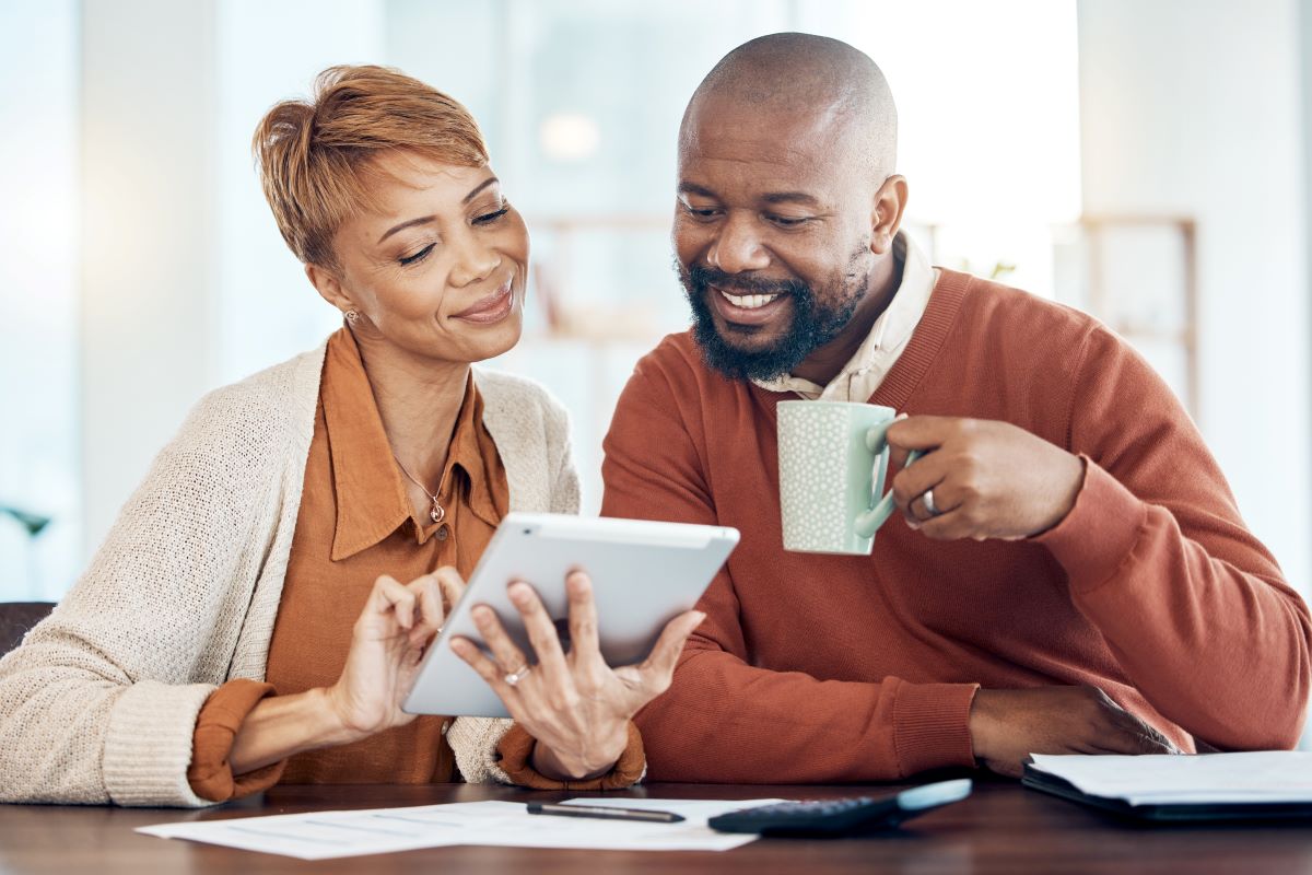 Couple looking at a laptop drinking coffee