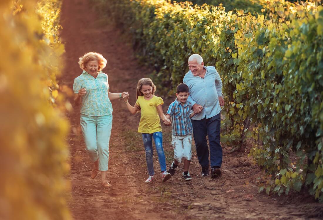 Senior couple with grandchildren running through a field