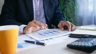 Businessman focused on a tablet computer while seated at a modern desk