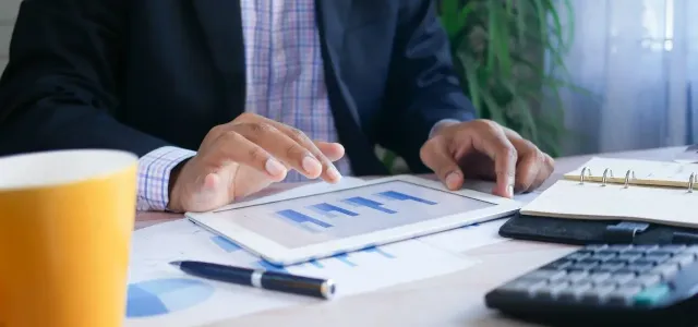 Businessman focused on a tablet computer while seated at a modern desk